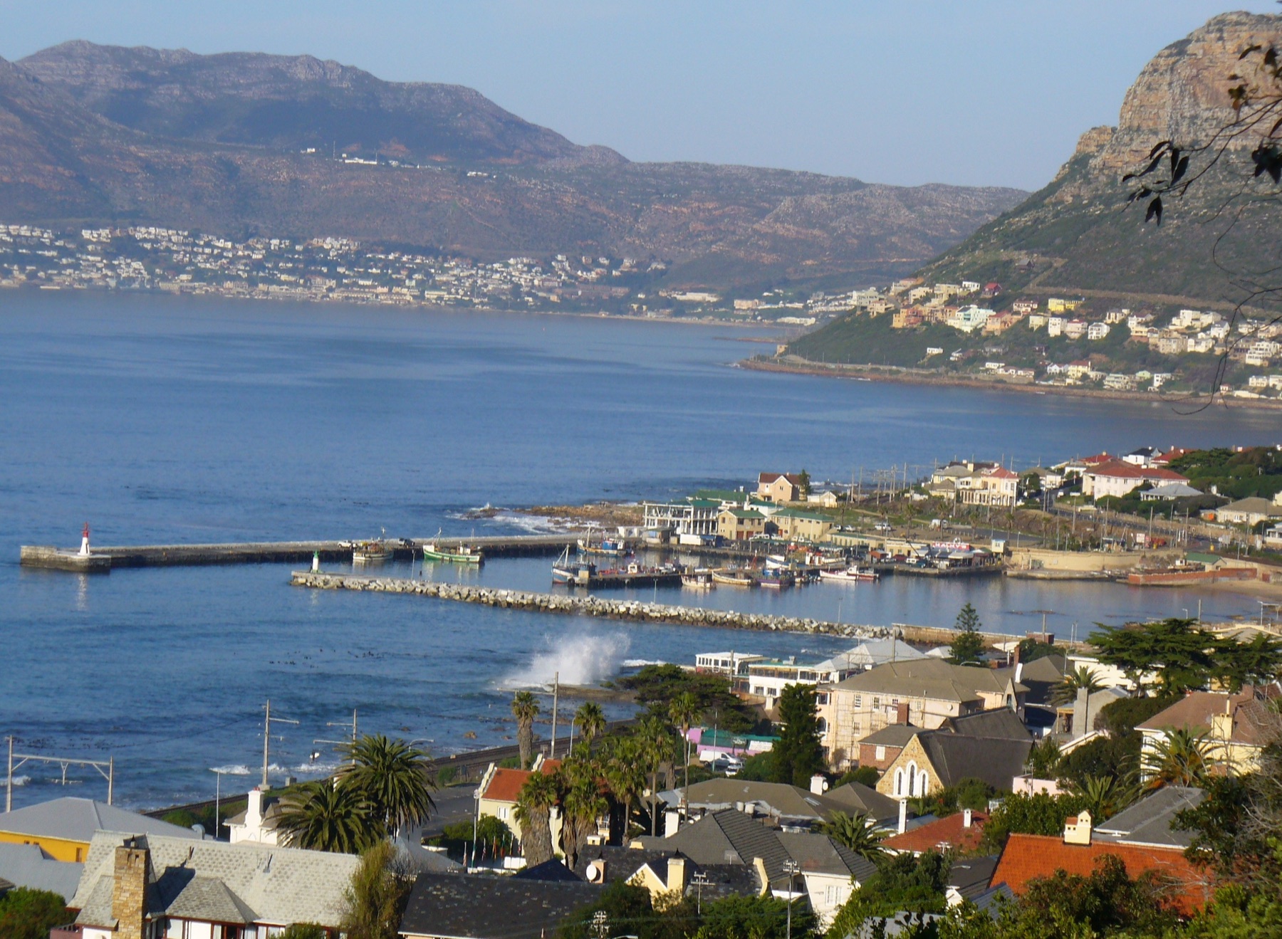 Kalk Bay's working harbour and village seen from above, with False Bay beyond